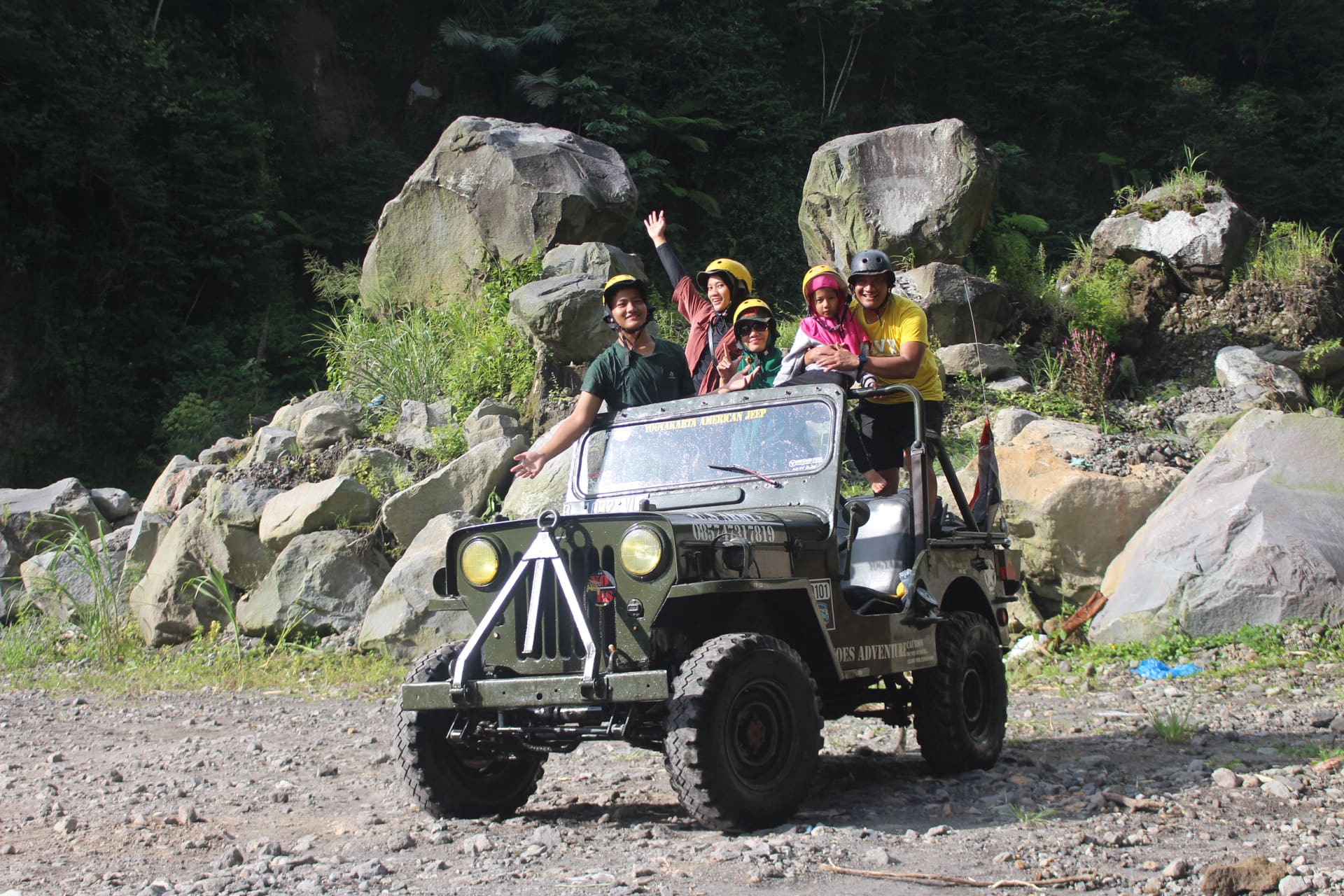 Keluarga berfoto bersama di dekat Jeep lava tour di area berbatu